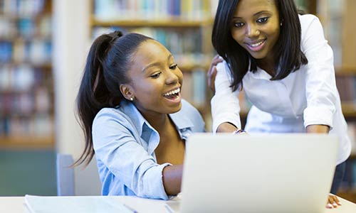 two diverse students looking at computer 