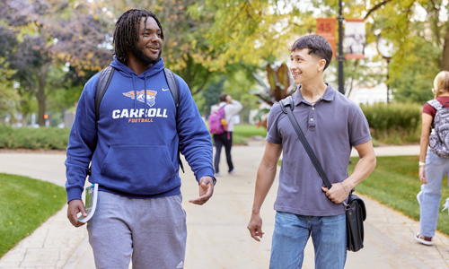 Two Carroll students talking and walking through campus.