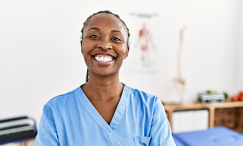 Physical therapy student in scrubs smiling in clinic