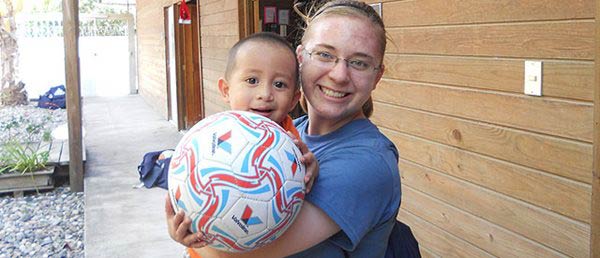 student and child with soccer ball