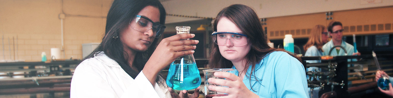 chemistry students looking at beaker