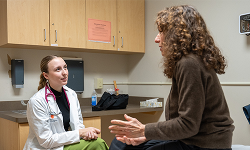 Student working with a patient in doctors office.