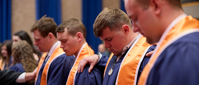 3 men in cap and gowns.