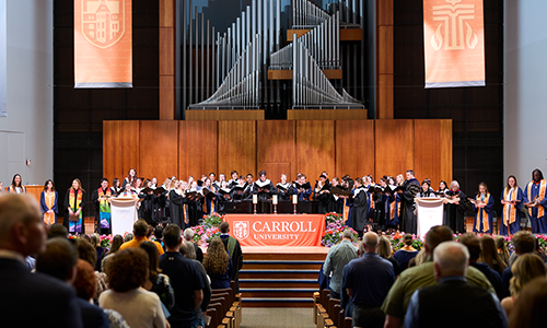 A group of students in the auditorium praying.