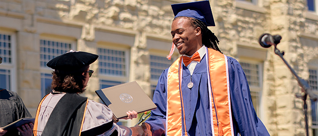 Student walking across stage during graduation.