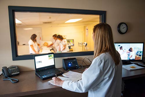 Instructor overseeing students in Hastad Hall Nursing Lab