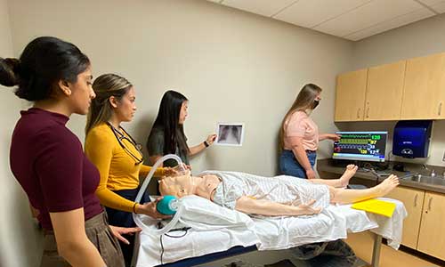 a group of Carroll University students practicing in a patient room.