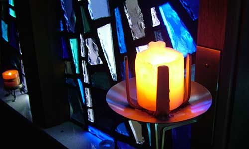 burning candle and stained glass window