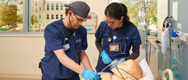 two Carroll University nursing students practicing.