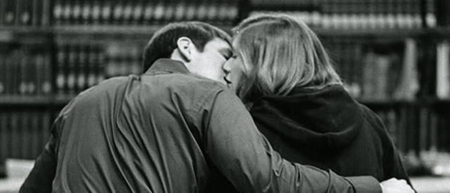 Carroll student and boyfriend studying, kissing in library