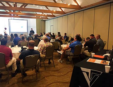 Attendees sit and are shown a powerpoint