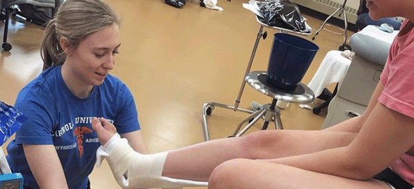 A PA student wraps an ankle