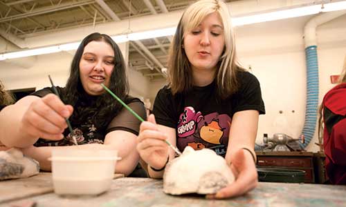two female students working on sculptures