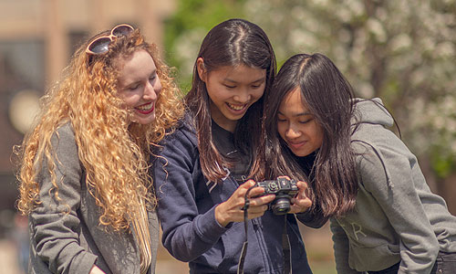 three Carroll University students looking at a camera.