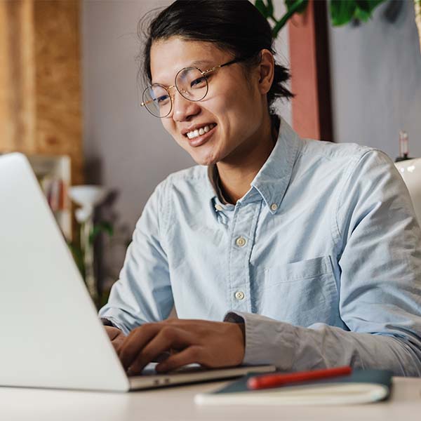 smiling student typing on laptop