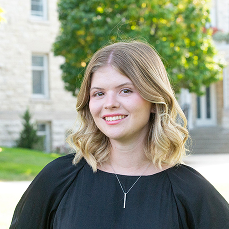 Women with blonde hair in a black blouse.