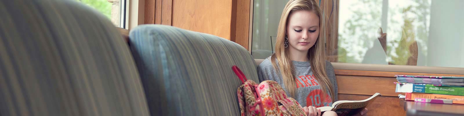 female student reading in the campus coffee shop