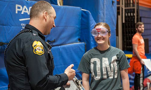Student in drunk goggles talking to a police officer