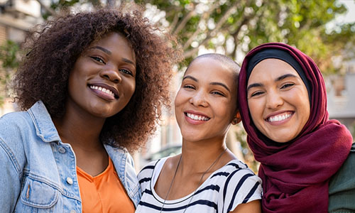 A group of diverse female students smiling for the camera. 