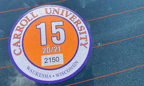 a close up of a Carroll University resident parking permit on a car.