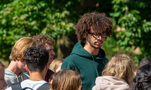 Group of Carroll University students gathered outdoors between classes on a sunny day.