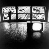 Surreal photograph of studio space with an intersection of traffic displayed in the window panes